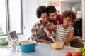 Happy african american family preparing healthy food in kitchen, having fun together on weekend Royalty Free Stock Photo