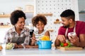 Happy african american family preparing healthy food in kitchen, having fun together on weekend Royalty Free Stock Photo