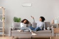 Happy african american family relaxing on sofa under air conditioner