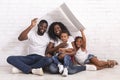 Happy African American Family Sitting On Floor Under Symbolic Roof Royalty Free Stock Photo