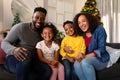 Happy african american family sitting on sofa and looking at camera Royalty Free Stock Photo