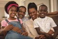 Happy African American family sitting on the sofa and looking at camera Royalty Free Stock Photo