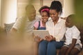 Happy African American family sitting on the sofa and using digital tablet Royalty Free Stock Photo