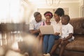 Happy African American family sitting on the sofa and using laptop Royalty Free Stock Photo