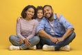 Happy african american family of three sitting on floor and embracing