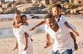 Happy african american family with two children enjoying vacation by the beach. Playful parents carrying their daughter Royalty Free Stock Photo