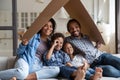 Happy African American family sitting on couch under cardboard roof
