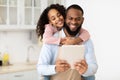 Happy African American family using tablet in the kitchen Royalty Free Stock Photo