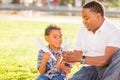 Happy African American Father and Mixed Race Son Playing with Paper Airplanes in the Park Royalty Free Stock Photo