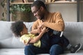 Happy African American father playing with toddler son at home Royalty Free Stock Photo