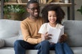 Happy African American father with preschool daughter reading book Royalty Free Stock Photo