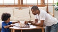 Happy African American Father and son playing chess game together Royalty Free Stock Photo