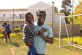 Happy african american father and son spending time together and playing football outside Royalty Free Stock Photo