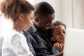 Happy African American young family watch cartoons on laptop Royalty Free Stock Photo