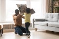 Happy African American father and toddler son playing pillow battle Royalty Free Stock Photo