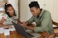 Happy african american father using tablet and daughter doing homework at home smiling Royalty Free Stock Photo