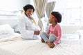 Happy african american female doctor talking to girl patient at hospital Royalty Free Stock Photo