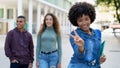 Happy african american female student with backpack and group of international students Royalty Free Stock Photo