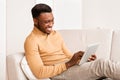 Happy Guy Using Tablet Computer Sitting On Couch At Home Royalty Free Stock Photo