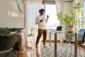 Happy African American hipster guy wearing headphones dancing to music at home. Royalty Free Stock Photo