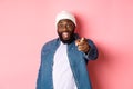 Happy african-american hipster man pointing finger at camera, need you, smiling excited, standing over pink background Royalty Free Stock Photo