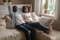 Happy biracial couple lying on couch dreaming together Royalty Free Stock Photo