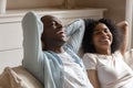 Happy biracial couple relax on cozy couch at home Royalty Free Stock Photo