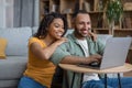 Happy african american husband and wife using laptop computer, browsing internet, resting together at home Royalty Free Stock Photo