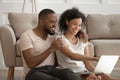 Happy african american loving family couple holding computer, watching photos. Royalty Free Stock Photo