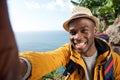 Happy african american male hiker with backpack taking selfie