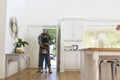 Happy african american male soldier embracing daughter at home, copy space