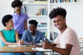 Happy african american male student learning at desk at school Royalty Free Stock Photo