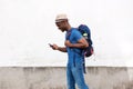 Happy african american man with bag walking with cellphone Royalty Free Stock Photo