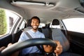 Happy african american man with beard driving car