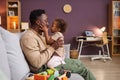 Happy African American man cuddling with little daughter at home Royalty Free Stock Photo