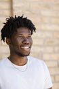 Happy African American man with dreadlocks walking down the street on a sunny day. Close-up portrait Royalty Free Stock Photo