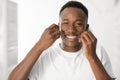 Happy African American Man Flossing Teeth Standing In Modern Bathroom Royalty Free Stock Photo