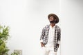 Happy african american man with hat leaning against white wall and laughing Royalty Free Stock Photo