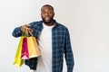 Happy african american man holding shopping bags on white background. Holidays concept Royalty Free Stock Photo