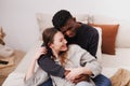 Happy african american man hugging cheerful girlfriend on bed at home Royalty Free Stock Photo