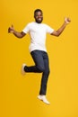 Happy african american man jumping and showing thumbs up