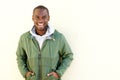 Happy african american man posing in windbreaker by wall