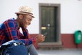 Happy african american man relaxing outside and looking at mobile phone Royalty Free Stock Photo