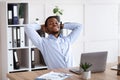 Happy african american man resting on his chair in office Royalty Free Stock Photo