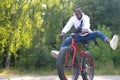 A happy African-American man rides a bicycle in the park