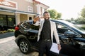 Happy African American man showing car key standing near new black car crossover outdoors. Young African American Royalty Free Stock Photo