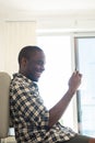 Happy african american man sitting on floor with mobile phone Royalty Free Stock Photo