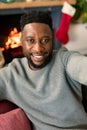 Happy african american man taking selfie, christmas decorations in background Royalty Free Stock Photo