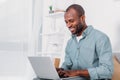 happy african american man using laptop on sofa Royalty Free Stock Photo