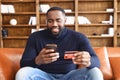 Happy African-American man using a smartphone for online shopping Royalty Free Stock Photo